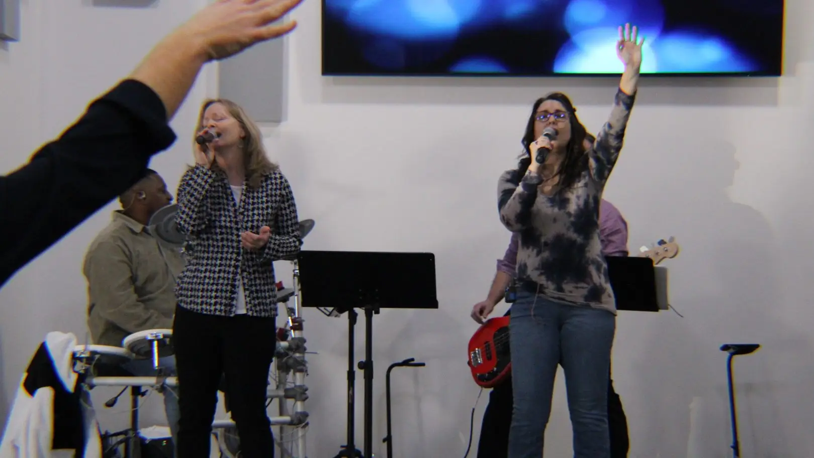 Two women singing with passion about Jesus